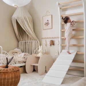 Children using wall bars inside a colorful playroom